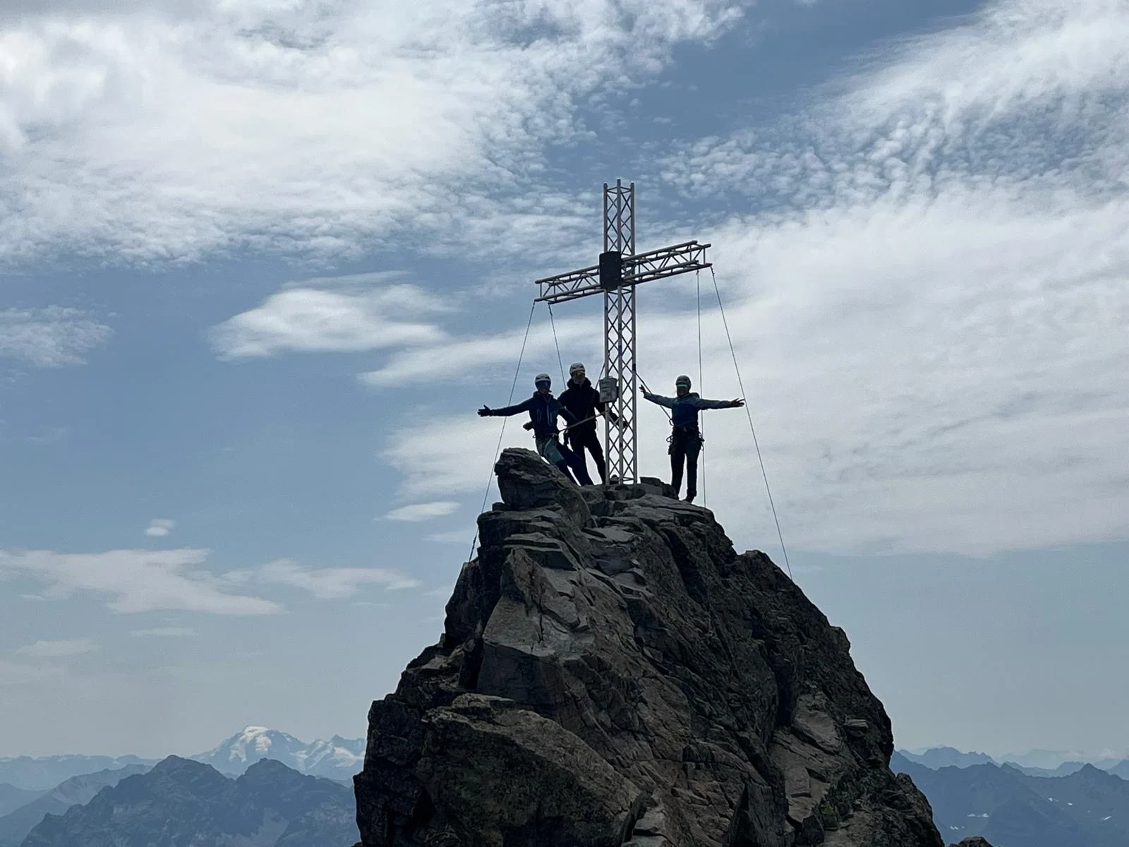Am Gipfelkreuz, im Hintergrund die Alpen